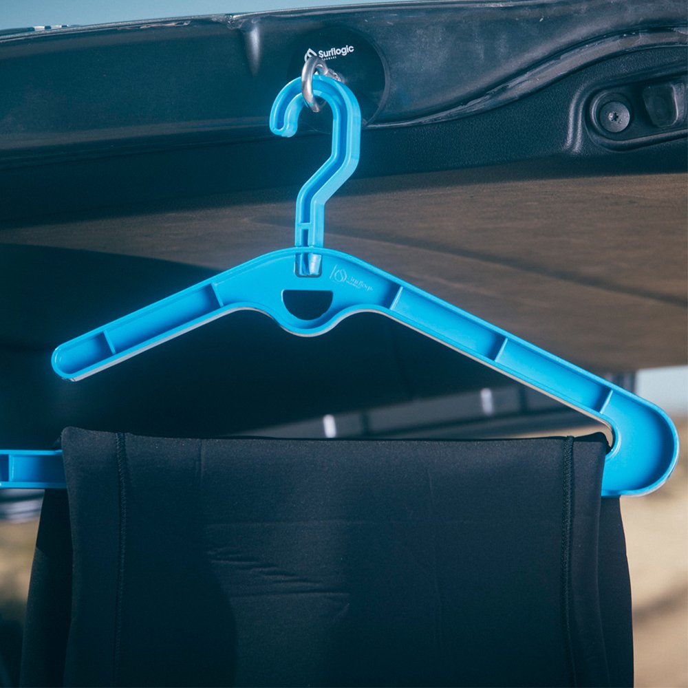 Blue plastic clothes hanger hooked to a car rack, with black wetsuit fabric hanging below.