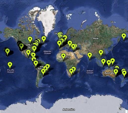 Mapa mundial com várias marcadores verdes apontando cidades ao redor do globo.