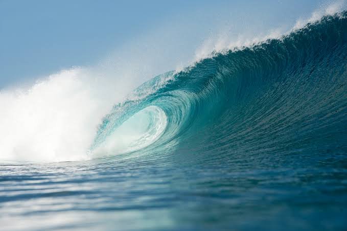 Wuchtige Meereswelle kurz vor dem Rauschen, blaues Wasser und Surfkunst.